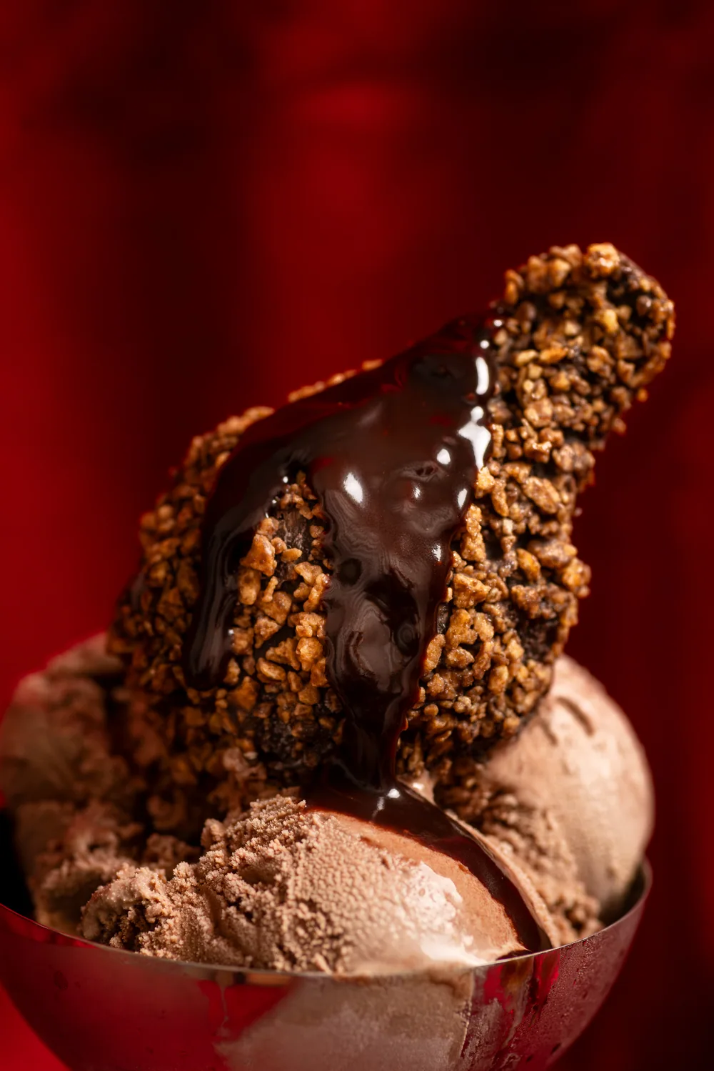 Chocolate-coated chicken-shaped ice cream over scoops of chocolate ice cream